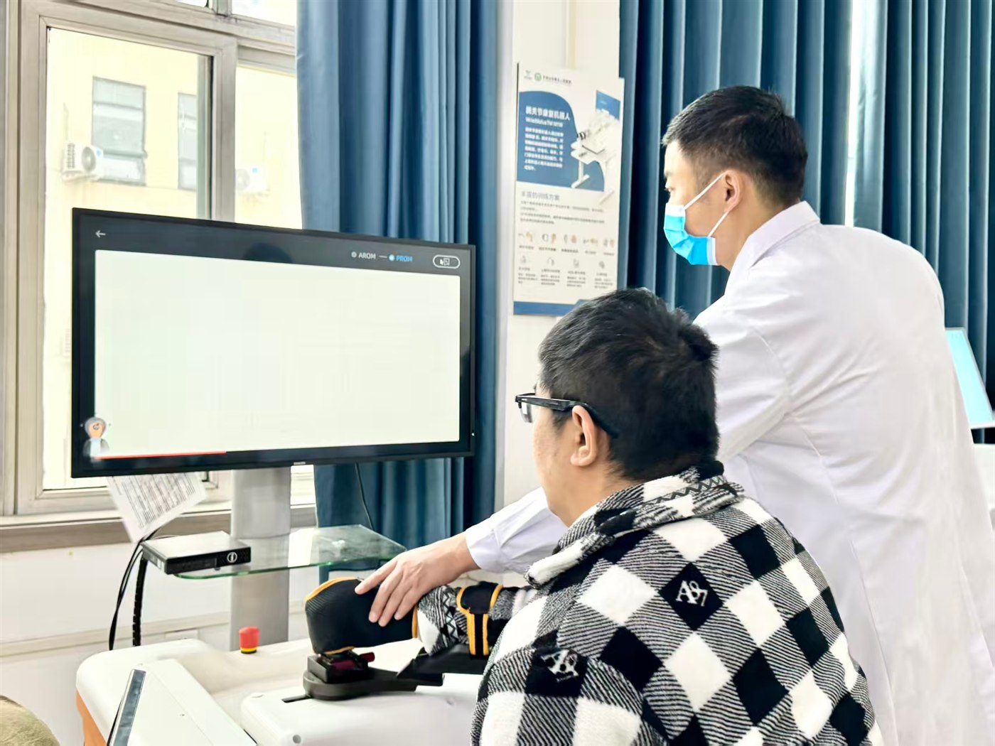 患者在治疗师指导下使用上肢康复机器人